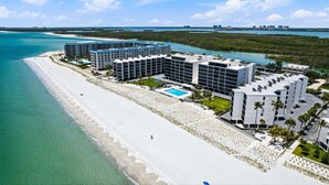 Ein Strandhotel mit mehreren Gebäuden, einem Pool und direktem Zugang zum Strand.