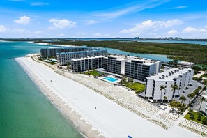 Ein Strandhotel mit mehreren Gebäuden, einem Pool und direktem Zugang zum Strand.