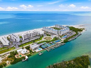 Een kusthotel met meerdere gebouwen, een jachthaven en een strand.