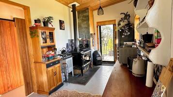 A cozy kitchen with wooden cabinets, a stove, and a dining area with a rug.