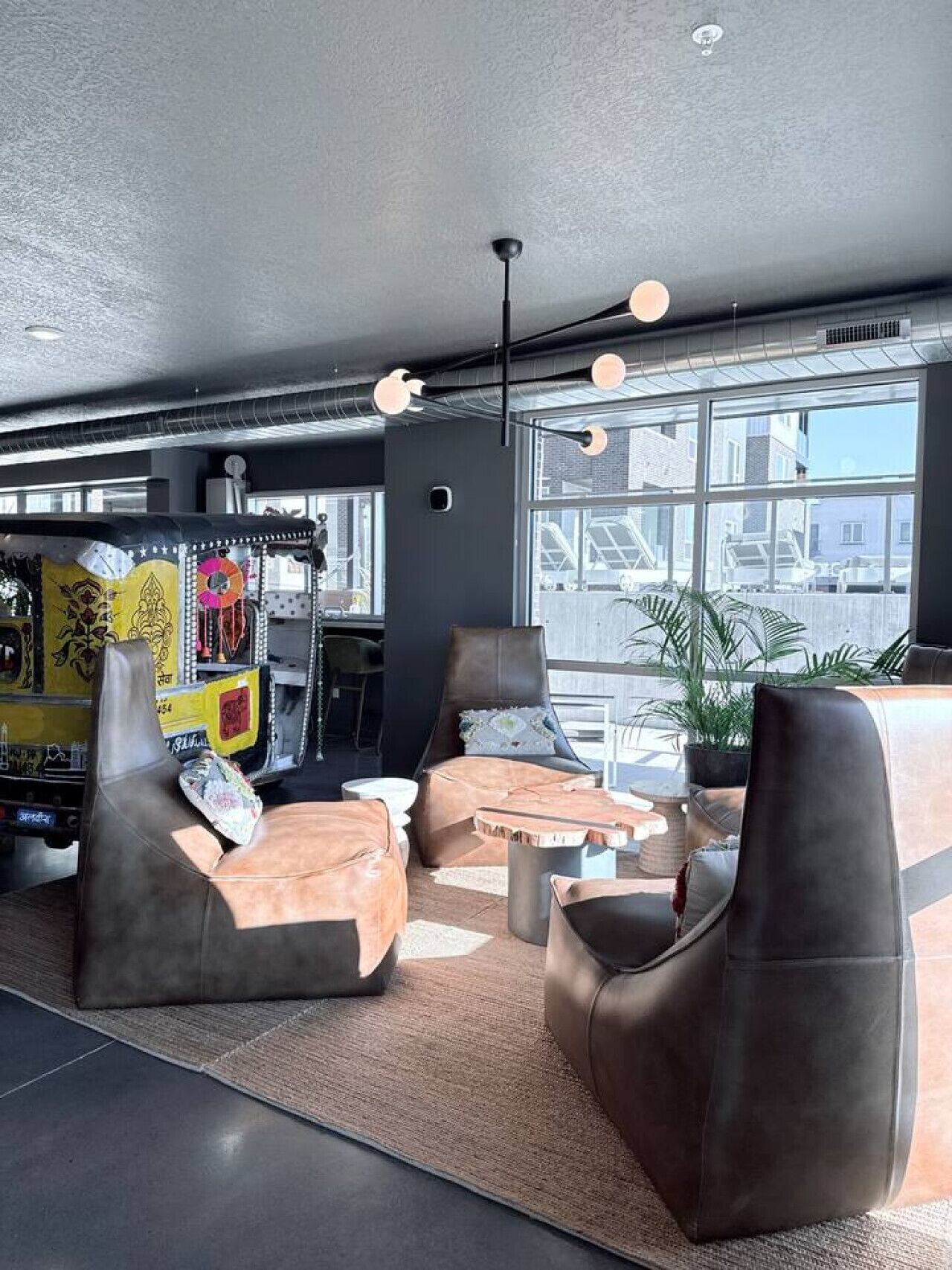 Ein moderner Lounge-Bereich mit Ledersofas, einem Couchtisch und einem großen Fenster mit Blick auf die Stadt.