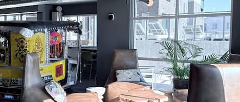 Un área de estar moderna con sofás de cuero, una mesa de centro y un amplio ventanal con vistas a la ciudad.