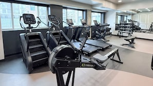 Et fitnessrum med flere løbebånd, træningscykler og styrkemaskiner.