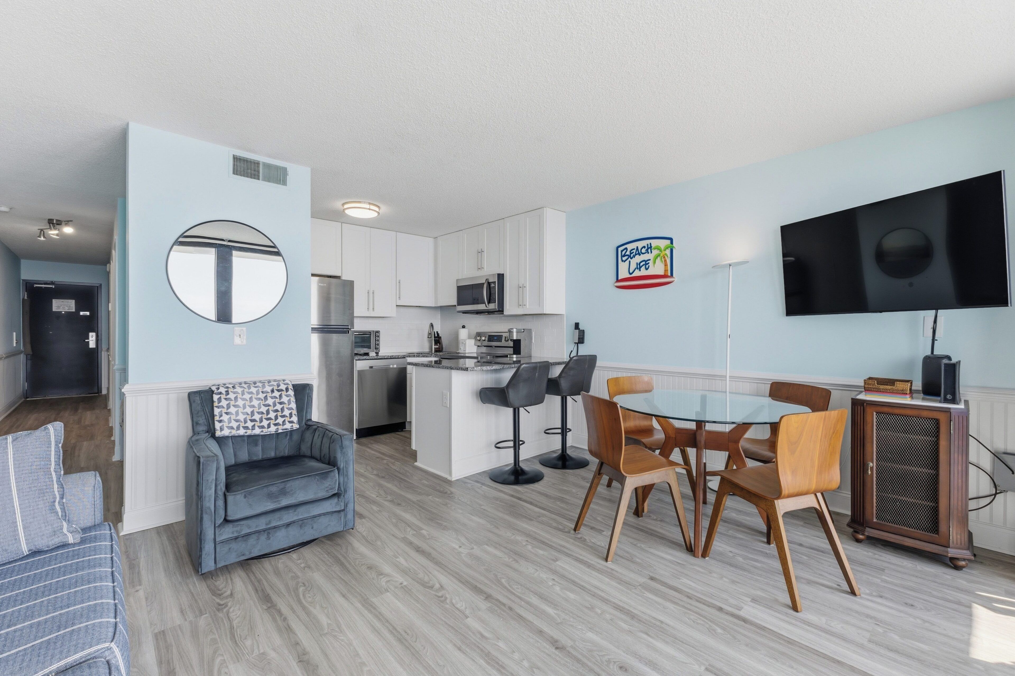 Um apartamento moderno com cozinha, sala de jantar e sala de estar.