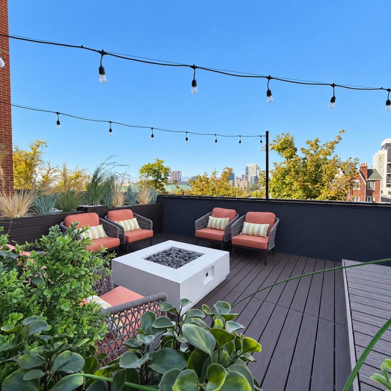 Eine Dachterrasse mit Sitzgelegenheiten im Freien, einer Feuerstelle und Lichterketten.