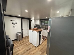 A compact kitchen with a central island, white cabinets, a microwave, and a refrigerator. - Amazingly located 2 bed 1 bath apart pet friendly (Chattanooga)