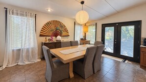 A dining area with a table, chairs, a decorative fan, and a lamp. - Peaceful & Spacious Zen Home near Chambers Bay (University Place)