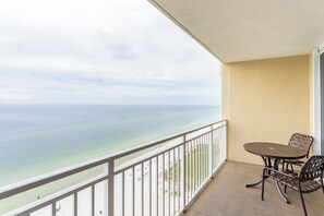 Un balcone con vista sull'oceano, un tavolo e due sedie.