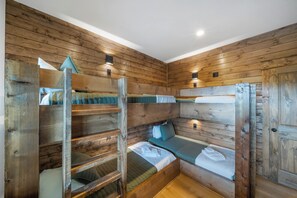 Ein Blockhauszimmer mit Holzwänden und Etagenbetten.