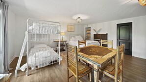 Ein Zimmer mit Etagenbetten, einem Esstisch und einer Kronleuchter.