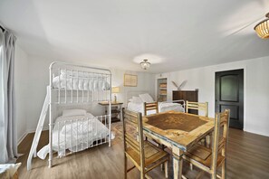 Ein Zimmer mit Etagenbetten, einem Esstisch und einer Kronleuchter.