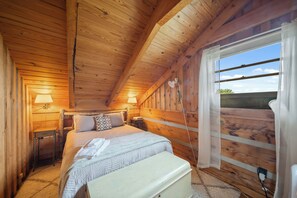 A cozy wooden room with a bed, bedside lamps, a window with a view, and a small table. - Secluded Mountain Escape with Incredible Views (Banner Elk)