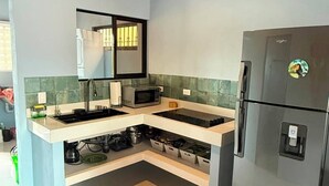 Une cuisine moderne équipée d’un four à micro-ondes encastré, d’un réfrigérateur et d’un évier.