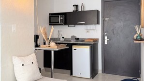 A compact kitchen with a microwave, coffee maker, and a small refrigerator.