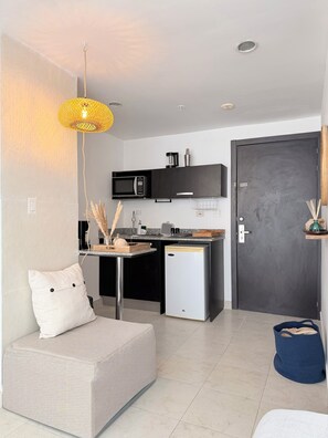 A compact kitchen with a microwave, coffee maker, and a small refrigerator.