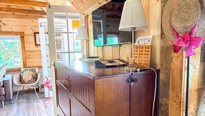 A wooden interior with a kitchen counter, a lamp, and a decorative hat. - Glamping in the Lake - Ovah to Camp! (Manchester)