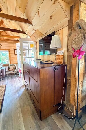 A wooden interior with a kitchen counter, a lamp, and a decorative hat.