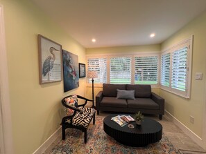 A living room with a sofa, a round coffee table, a patterned rug, and a chair. - The Pines Hideaway Guesthouse, two bedroom house two bathroom. (Wilton Manors)
