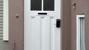 A white door with a window and a keypad lock. - Cozy Inner Richmond Apartment, Steps to Golden Gate Park (San Francisco)