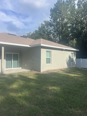 A single-story house with a flat roof, a front door, and a small front yard.