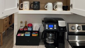 A kitchen with a coffee maker, a stove, and a cabinet with spices and condiments. - Desert Retreat / Brand new interior / Pool / Views (Bullhead City)