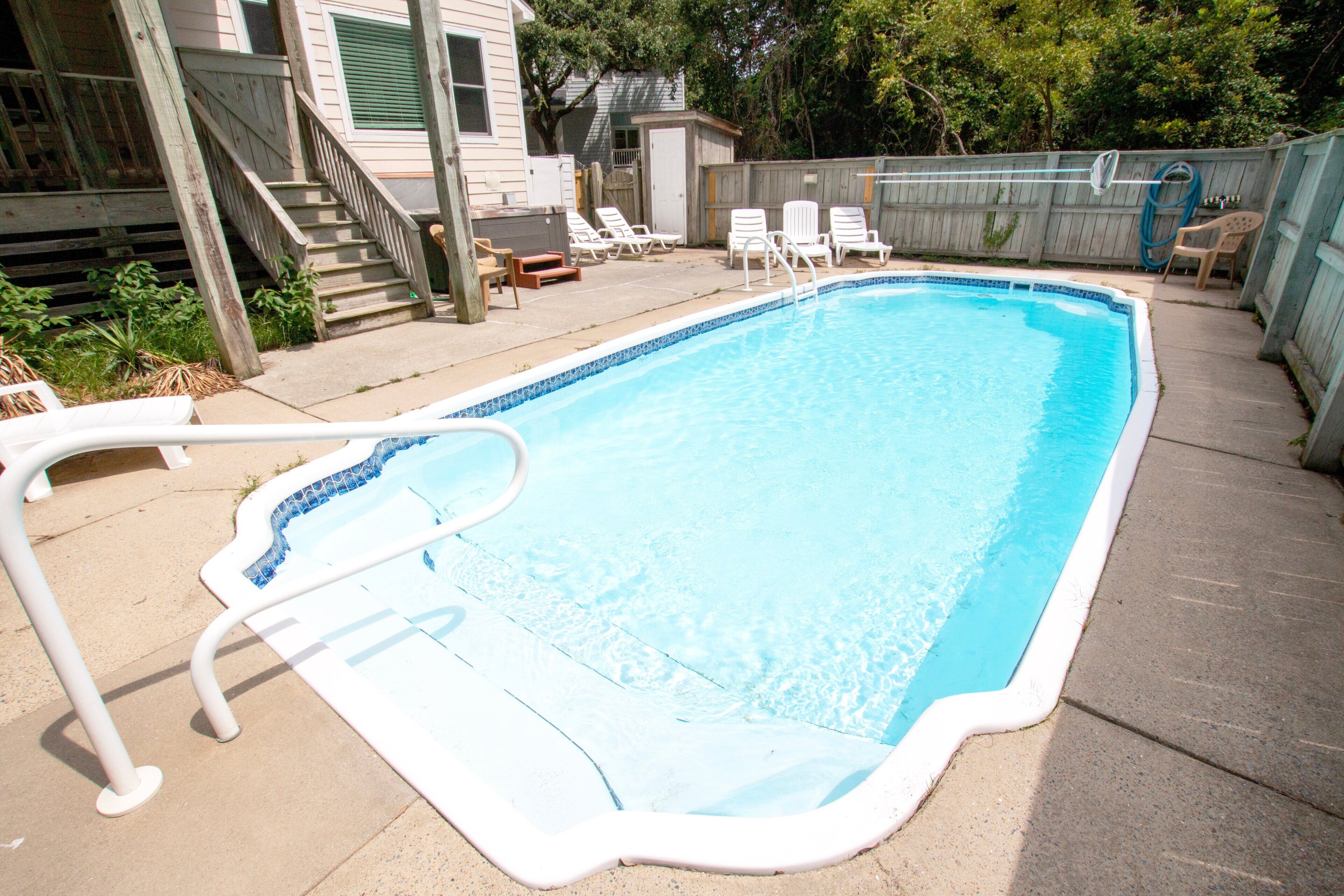 A rectangular swimming pool with a white edge and a blue tile pattern.