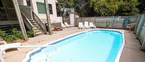 A rectangular swimming pool with a white edge and a blue tile pattern.
