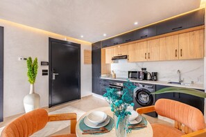 A modern kitchen with dark cabinetry, a built-in oven, and a microwave. - 1-bedroom apartment in tranquil Marrakech with AC (Marrakech)