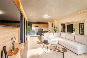A modern living room with a sofa, coffee table, and a dining area. - 1-bedroom apartment in tranquil Marrakech with AC (Marrakech)