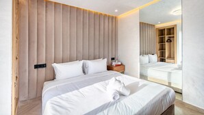 Quarto moderno com uma cama grande, cabeceira de madeira, mesa de cabeceira com abajur e espelho de corpo inteiro.