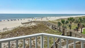 A beach with a wooden boardwalk, beach umbrellas, and a clear view of the ocean. - Gulf Front | 2 Kings | Private Balcony & Beach Access | BEACHBALL PROPERTIES (Orange Beach)