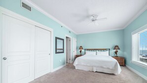 A bedroom with a bed, a nightstand, a lamp, a ceiling fan, and a window with blinds. - Gulf Front | 2 Kings | Private Balcony & Beach Access | BEACHBALL PROPERTIES (Orange Beach)