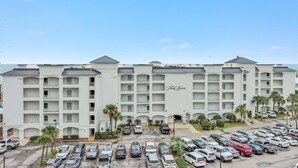 A multi-story hotel with a parking lot full of cars. - Gulf Front | 2 Kings | Private Balcony & Beach Access | BEACHBALL PROPERTIES (Orange Beach)