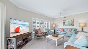A living room with a television, a sofa, a coffee table, and a chair. - Gulf Front | 2 Kings | Private Balcony & Beach Access | BEACHBALL PROPERTIES (Orange Beach)