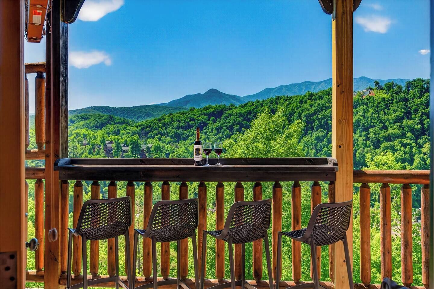 A wooden deck with a view of a forested mountain range.