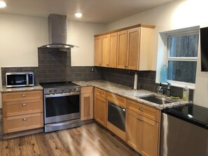 A kitchen with wooden cabinets, a stainless steel range, a microwave, and a dishwasher. - Cute one bedroom mother-in-law suite with hot tub in peaceful Woodinville  (Woodinville)