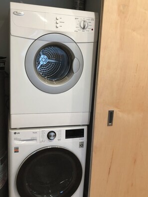 A stacked washer and dryer unit with control panels and a door. - Cute one bedroom mother-in-law suite with hot tub in peaceful Woodinville  (Woodinville)