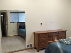 A bedroom with a bed, a dresser, a mirror, and a window with blinds. - Cute one bedroom mother-in-law suite with hot tub in peaceful Woodinville  (Woodinville)