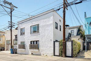 Un bâtiment à deux étages, à l’extérieur blanc, doté de nombreuses fenêtres et d’une entrée fermée par un portail.