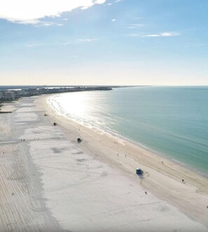 A beach with a long stretch of sand, a few people, and a clear sky. - 1 bedroom condo at Siesta Key beach. Full ocean views from your lanai (Siesta key, Sarasota)