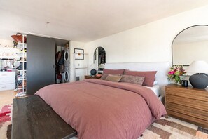 A bedroom with a bed, a nightstand, a dresser, a mirror, and a wardrobe. - Roomy apartment in Capitol Hill Seattle (Seattle)