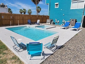 A swimming pool with two separate sections, surrounded by a wooden fence, and equipped with lounge chairs and sun loungers. - Isla Bella - 3BR, Private Pool, Near SP Beach (South Padre Island)