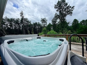 A hot tub on an outdoor deck with a wooden railing and surrounded by trees. - Mountain Top Farmhouse Retreat /Hot Tub/Arcade (Cosby)