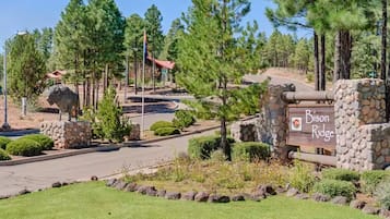 A sign for Bison Ridge with a stone wall and a bull statue.