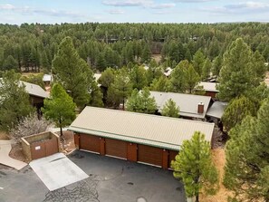 Un quartier résidentiel composé de plusieurs maisons, entouré d’une forêt dense.