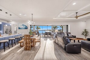 Une cuisine moderne dotée d’un grand îlot central, d’un coin repas offrant une vue agréable et d’un espace détente avec vue.