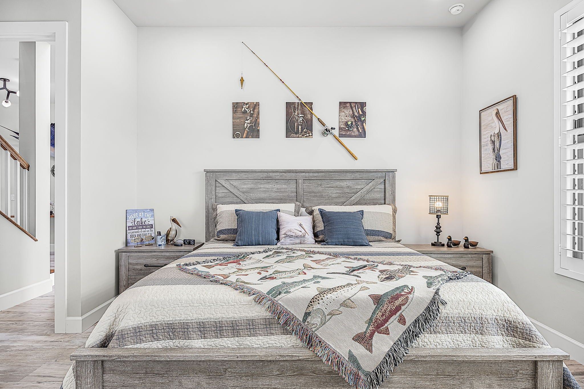 Un dormitorio con cama, mesitas de noche, un reloj de pared y cuadros enmarcados.