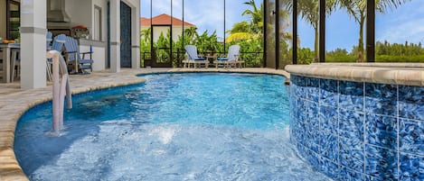 A swimming pool with a tiled edge, lounge chairs, and a covered area with a ceiling fan.