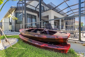 Ein Boot liegt auf einer Wiese, im Hintergrund ein modernes Gebäude.