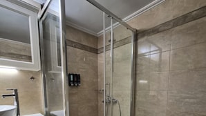 Ein Badezimmer mit Duschkabine, Waschbecken in Weiß und Toilette.